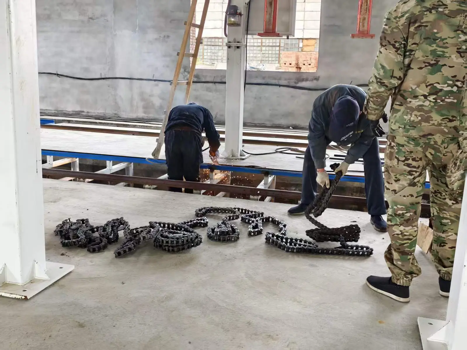 Technicians installing drive components beside Hengde production-line rails