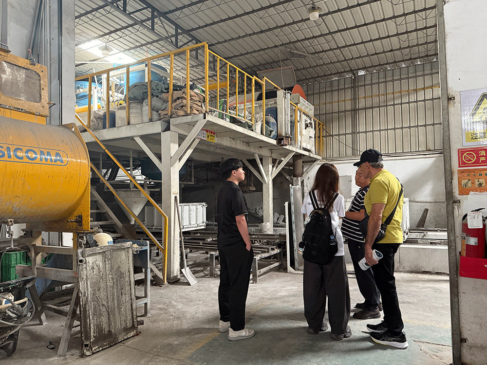 Brazil project team reviewing HENGDE lightweight wall panel production equipment — factory visit image 3