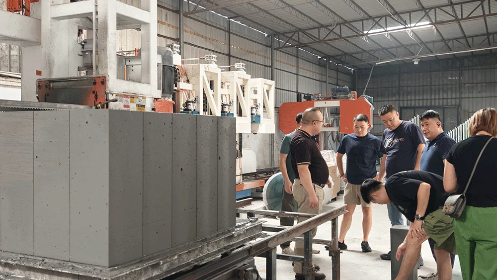 Ghanaian customer inspecting cut lightweight blocks beside HENGDE cutting equipment