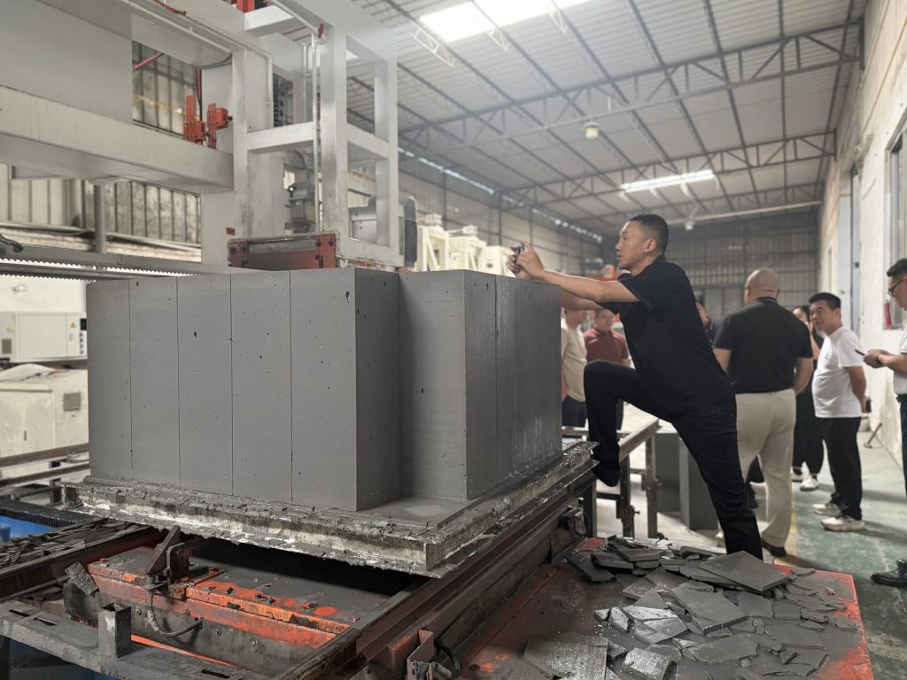 Malaysian project team reviewing freshly cut lightweight concrete blocks at Hengde factory