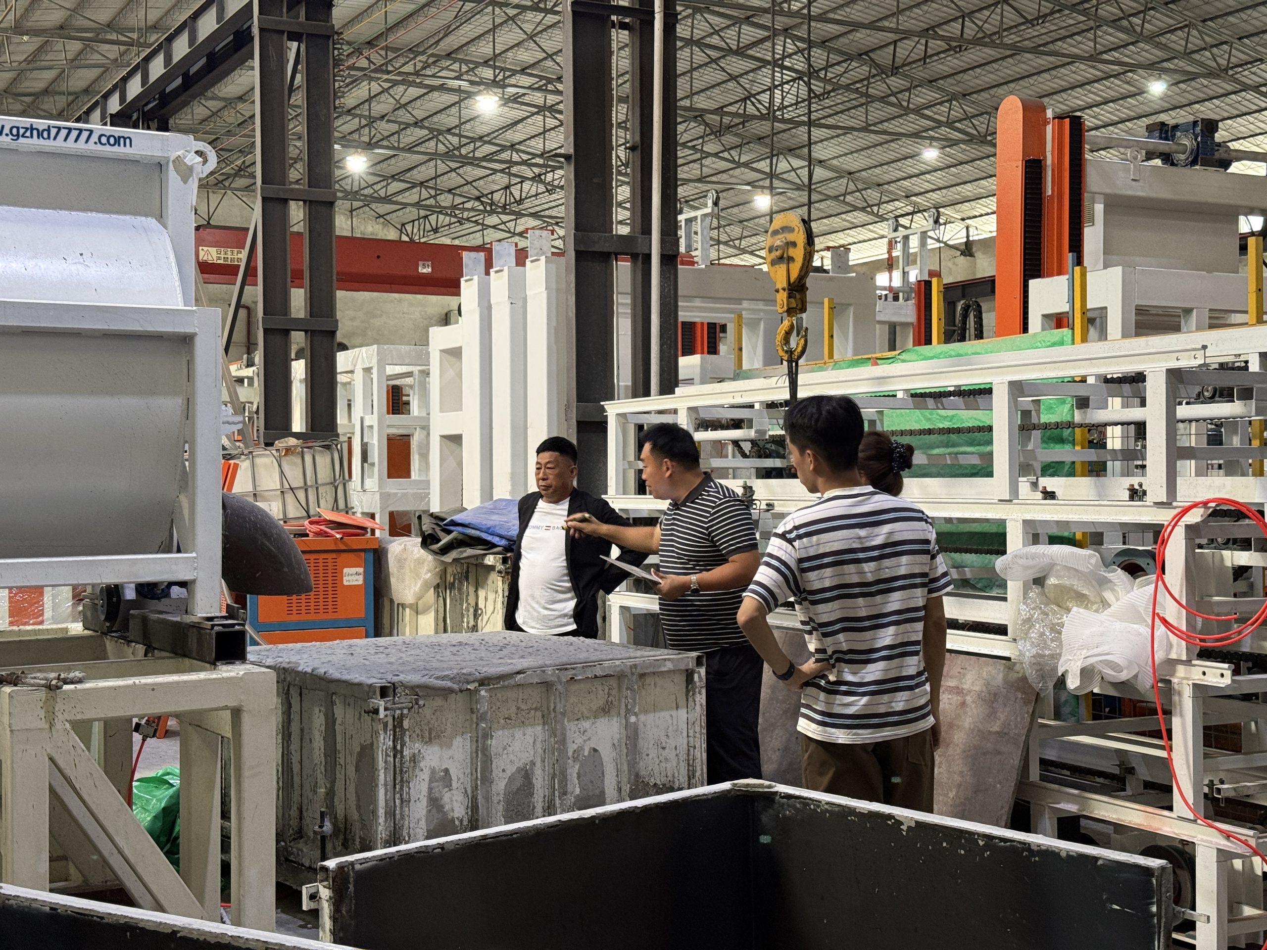 Timor-Leste customers and HENGDE personnel beside block-making equipment and moulds.